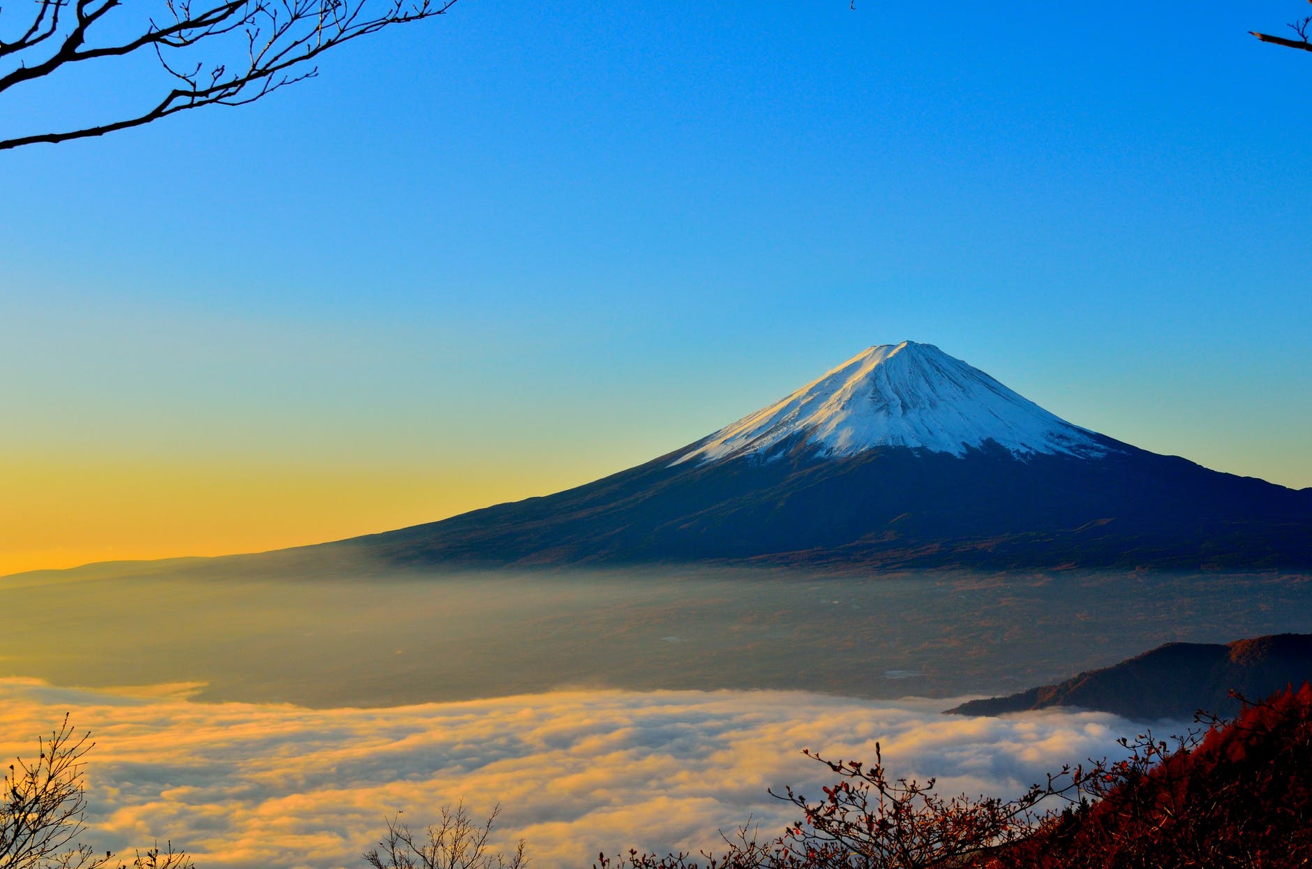 black and white mountain over yellow white and blue sky