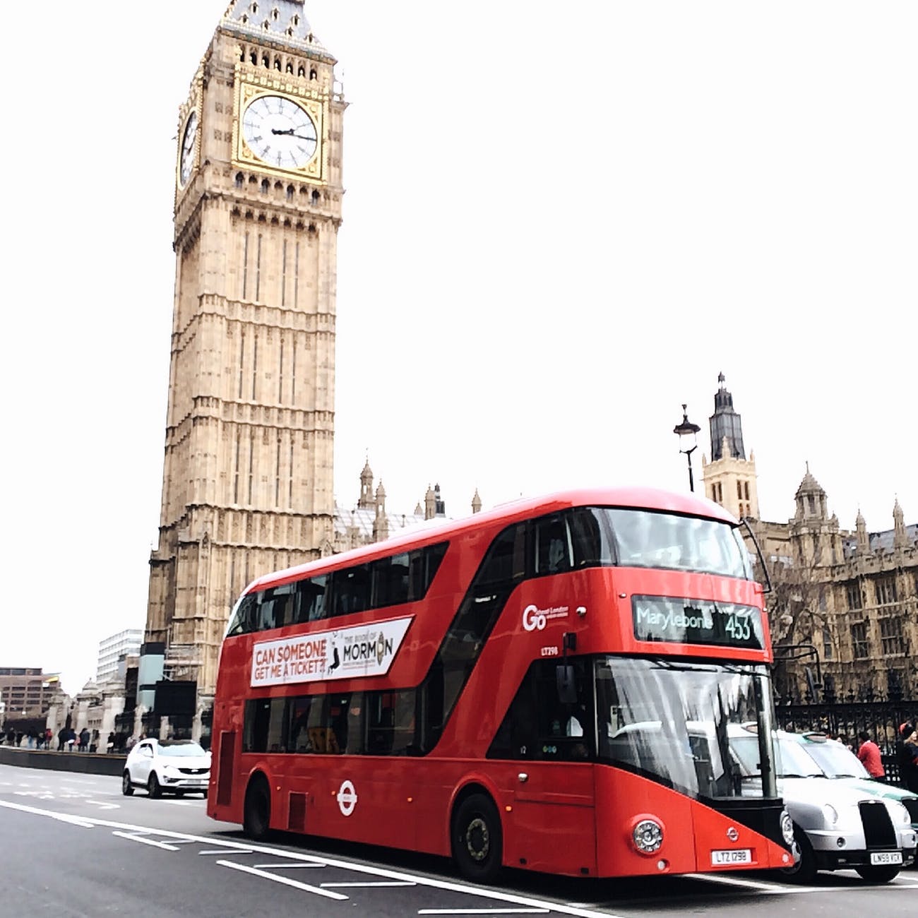 photo of red double decker on pavement road